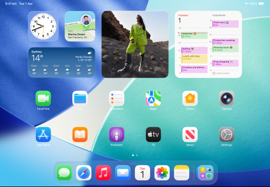 iPad, three models, landscape orientation, with centre model in front of two others, Apple Pencil magnetically attached to top of centre model, centre screen showing the Home Screen featuring colourful app icons with Liquid Glass effect, left screen showing the Preview app, right screen showing Home Screen with files fanning out from the dock