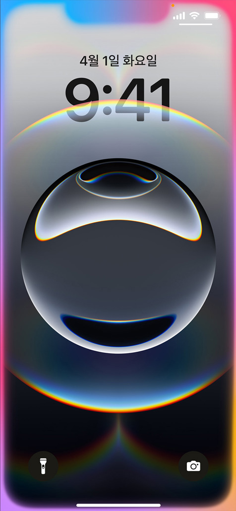 잠금 화면 가장자리가 다채로운 색상으로 빛나고 있는 iPhone 16e를 한 손으로 들고 있는 모습.