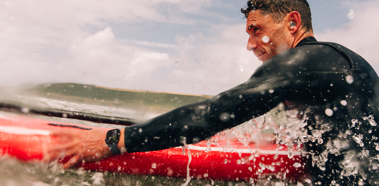 一位男士戴著 Apple Watch 衝浪。