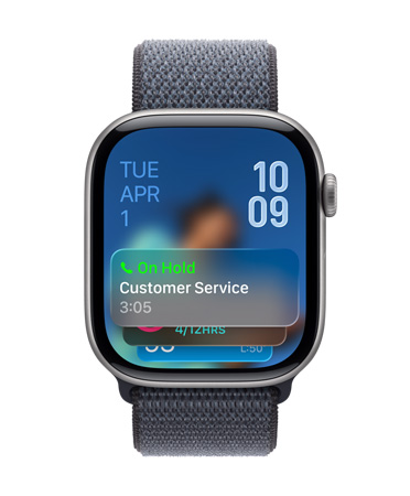 Apple Watch in Jet Black with a Sage Band, face shows Hold Assist notification at bottom, date on top left, time numerals stacked at top right